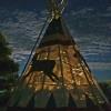 The Apache tipi iluminated at night.   The affect of being made from skins is successful!!   From a distance, one would never know the tipis are actually made of canvas.